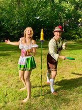Load image into Gallery viewer, a man and woman playing bottle bash dressed in lederhosen
