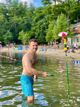 Load image into Gallery viewer, a man playing bottle bash in a lake
